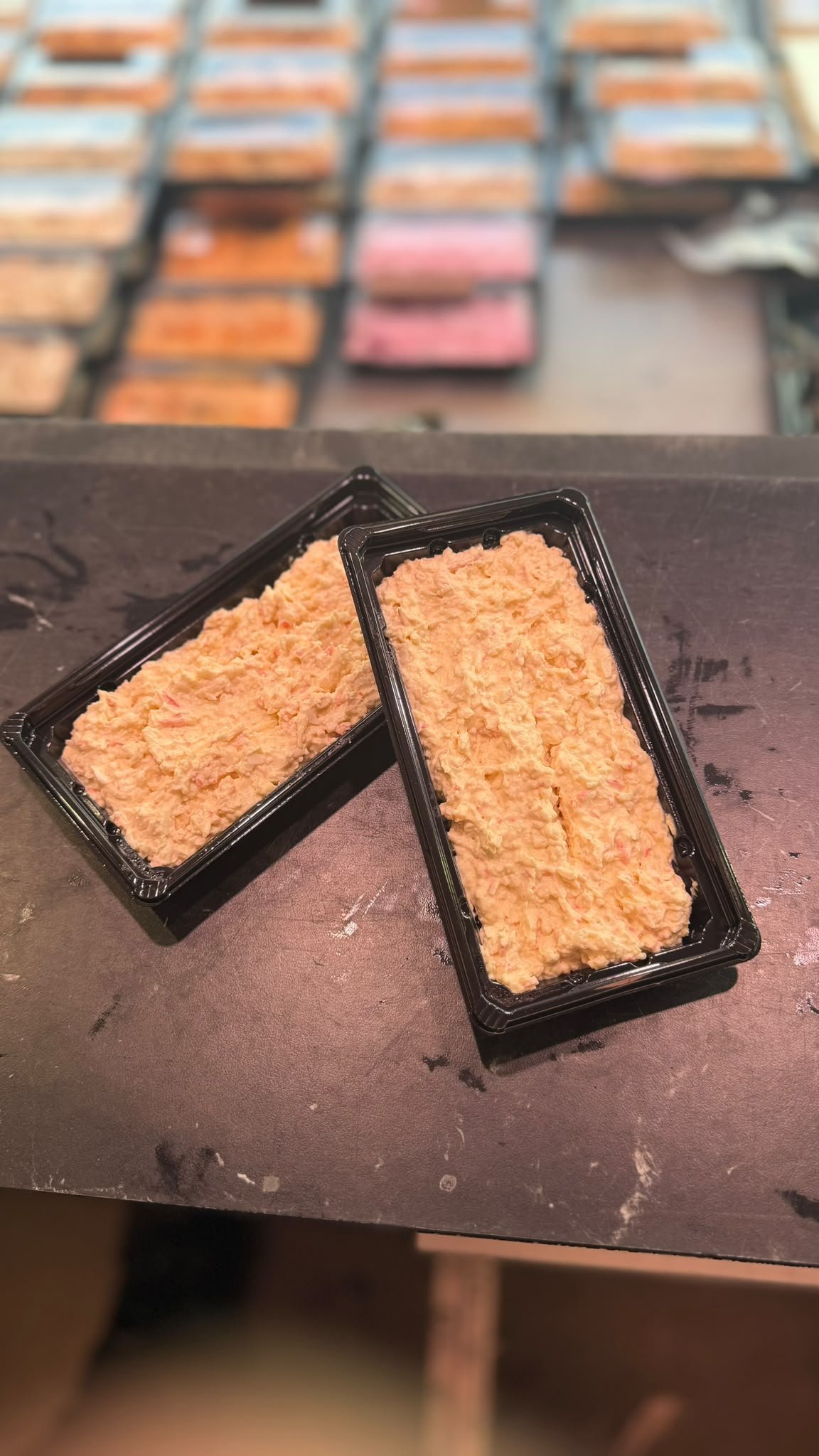 Huisgemaakte zalmsalade in bakjes, klaar voor verkoop